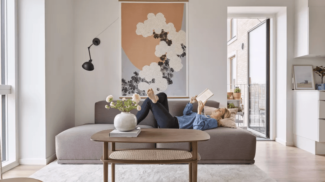 Woman relaxing on a sofa in an apartment in the property Strandby Huse