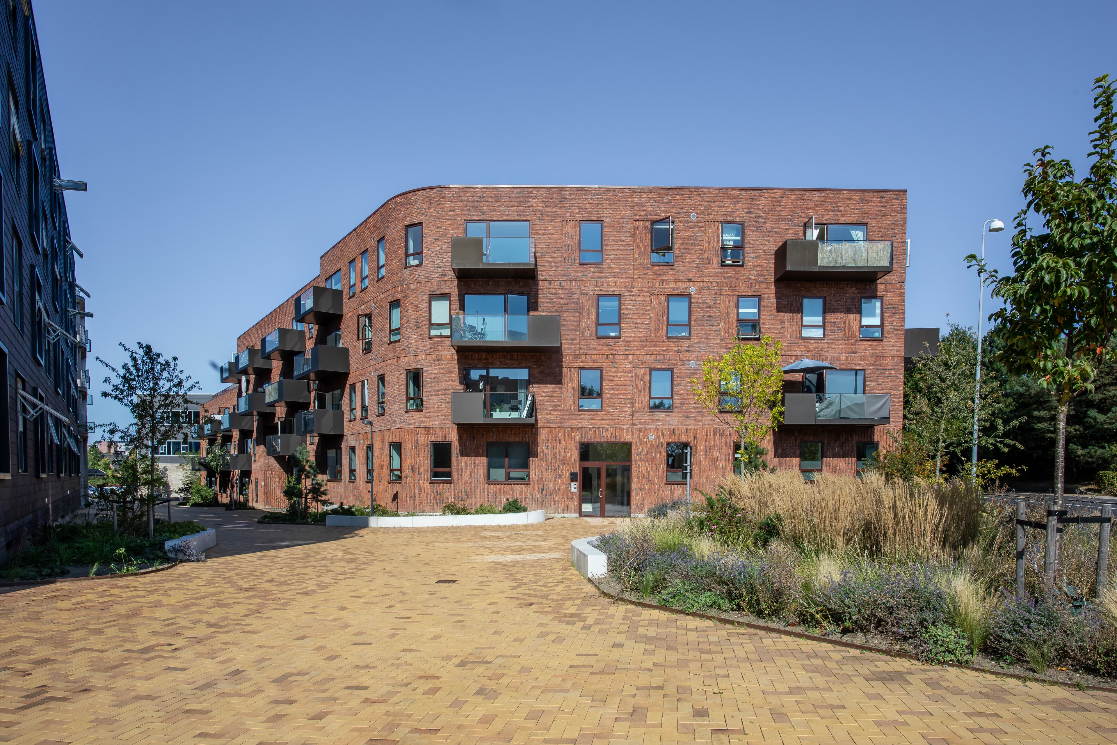 Balder's ejendom Carlsbakken, som er placeret i Hillerød by. Billedet er taget udfra ejendommen og viser ejendommesn facade og udendørs beplantning.