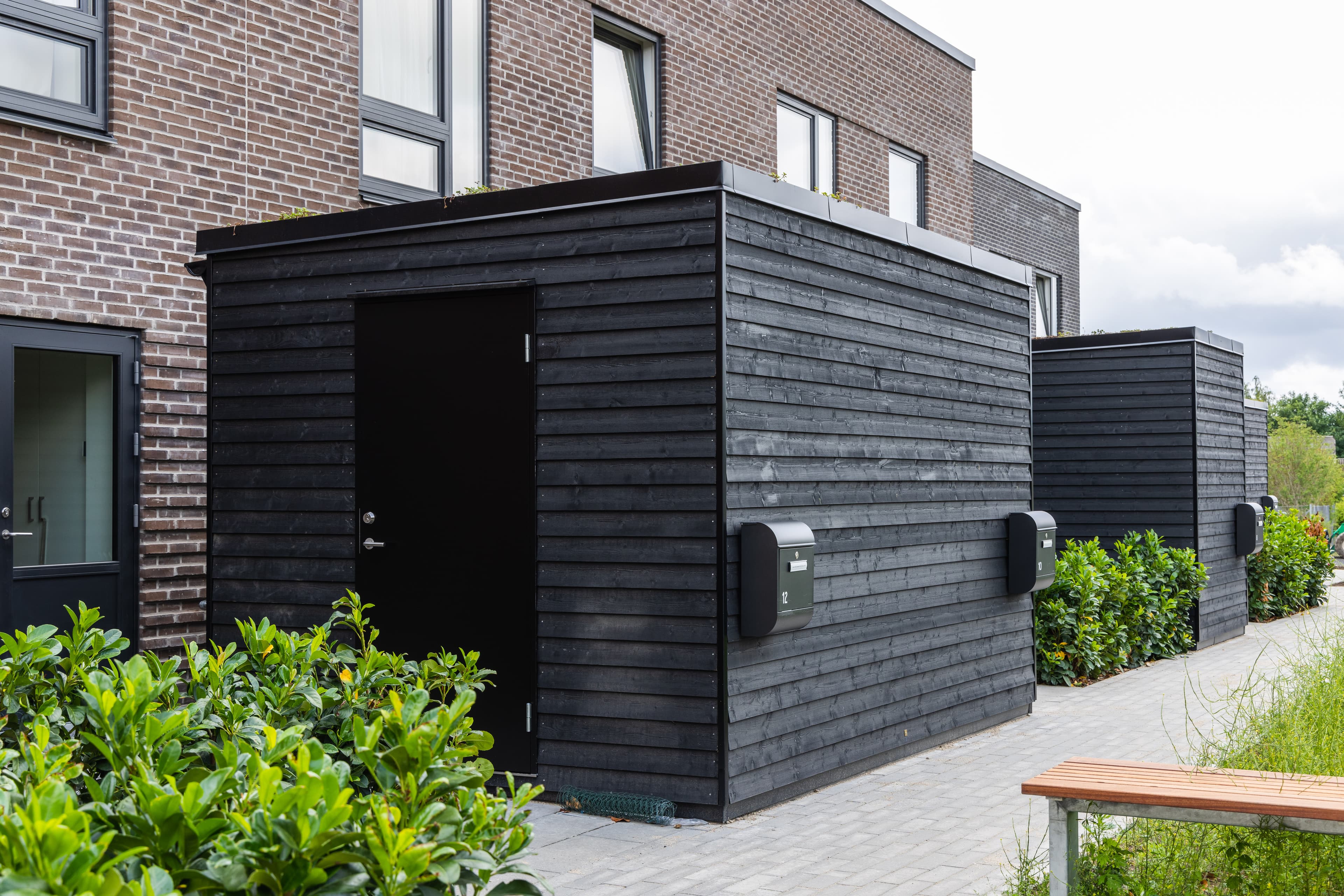 Dette billede viser facade og tilhørende cykelskur til rækkehusene TriumphHusene i Espergærde