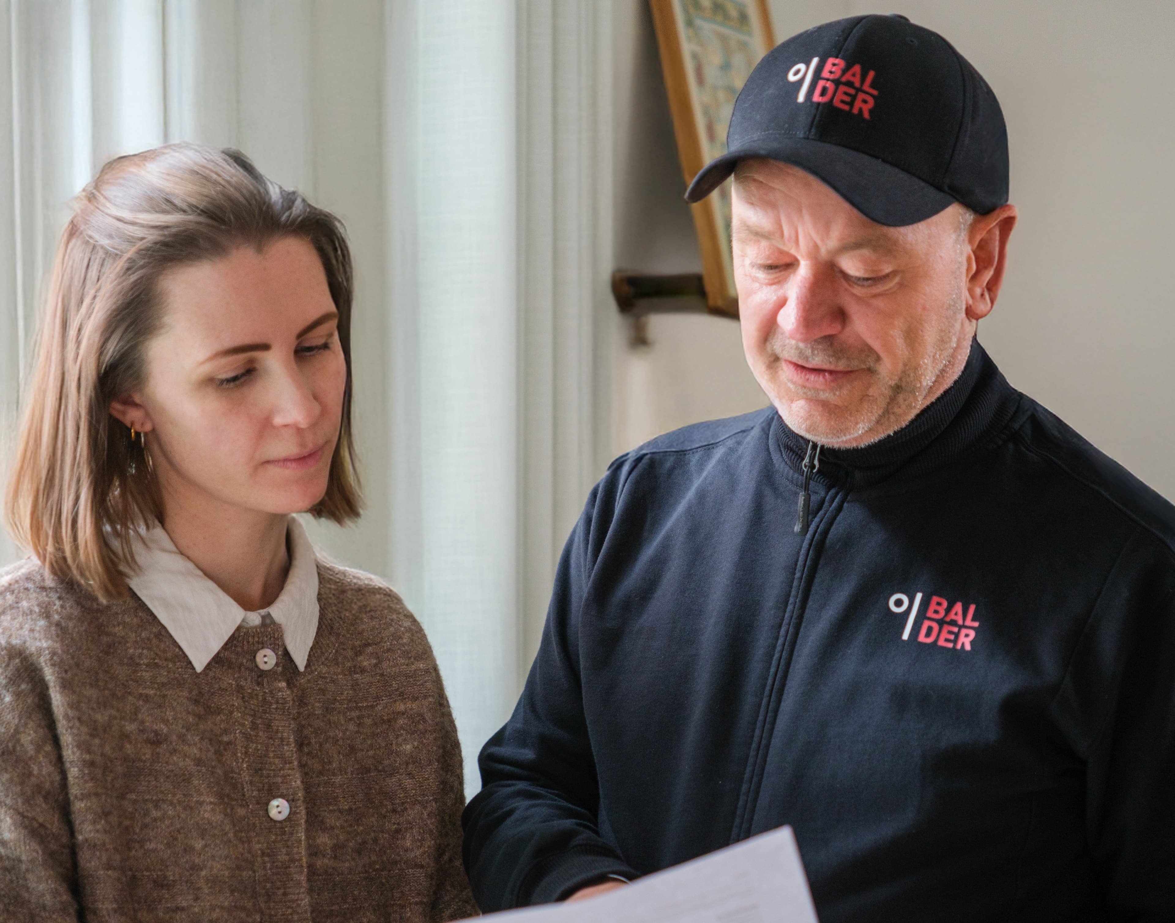 A Balder employee reviews a document together with a female customer.