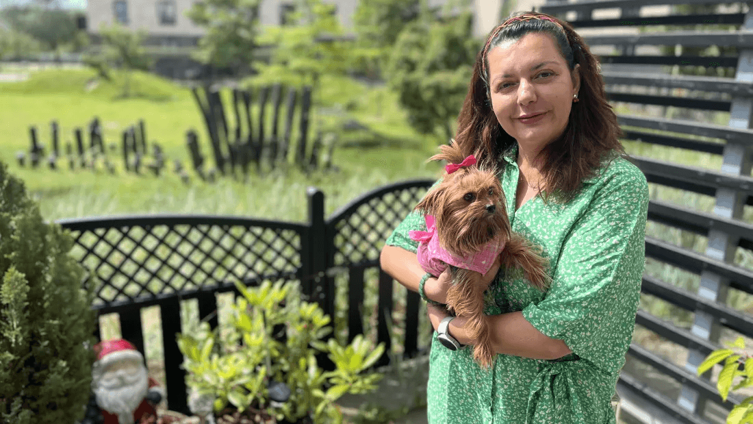 Sarah Aslani stands with her dog on her terrace at Øresund Park on Amager