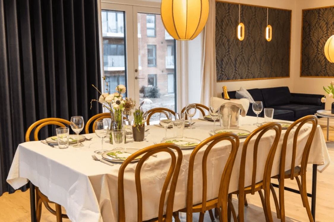 The common room with a set dining table in the TriumphByen property in Espergærde