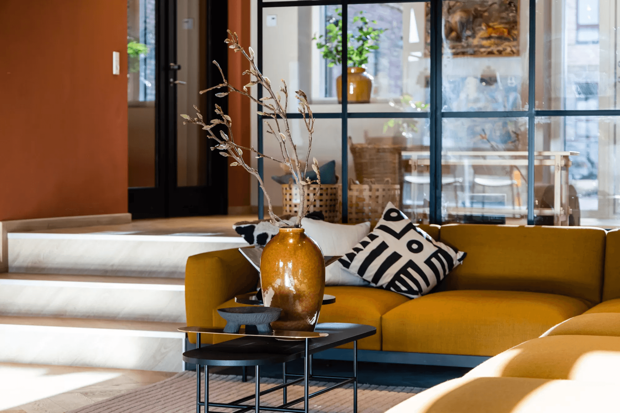 A yellow couch and table in the common room in the property Rubinhaven in Høje Taastrup
