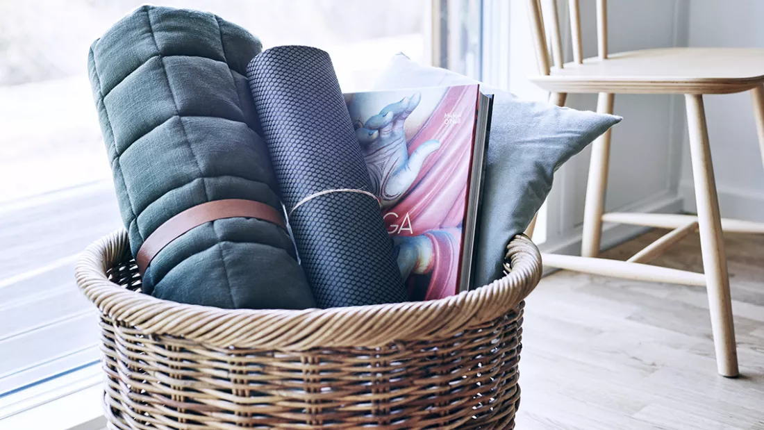 Basket of blankets, yoga mat and magazine