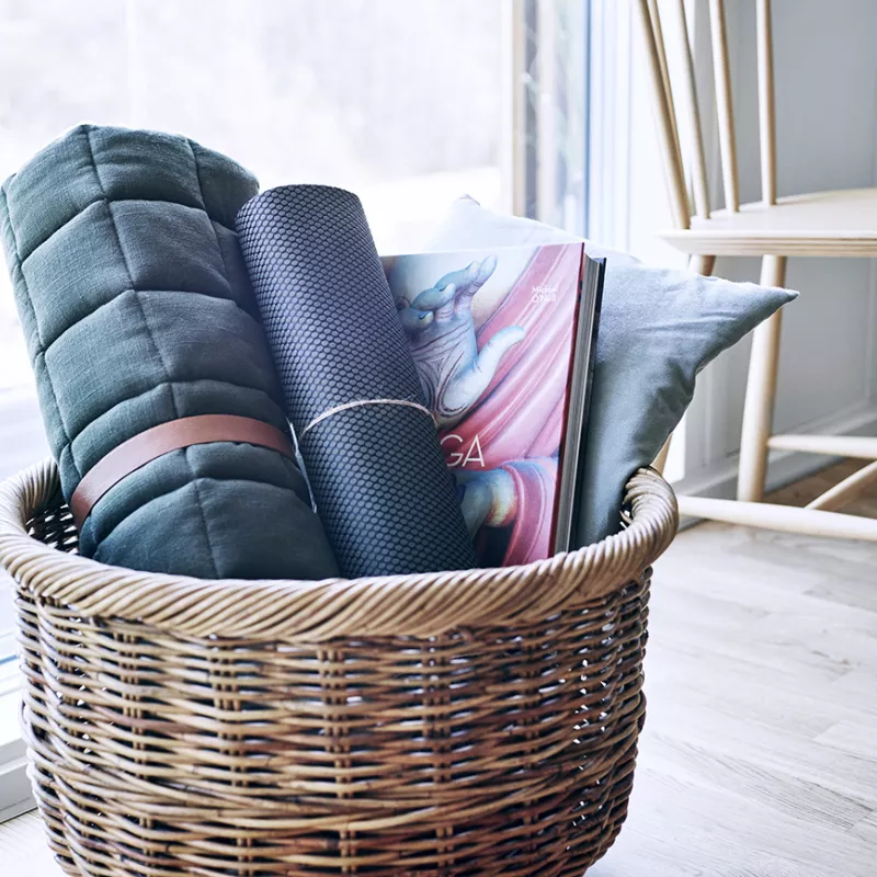 Basket of blankets, yoga mat and magazine